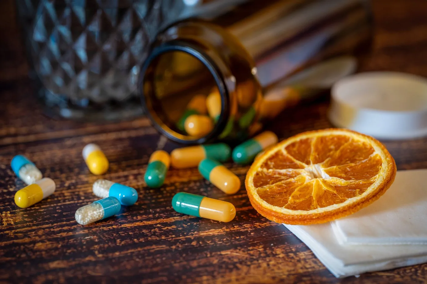 barevné vitamínové tablety a sušený pomeranč