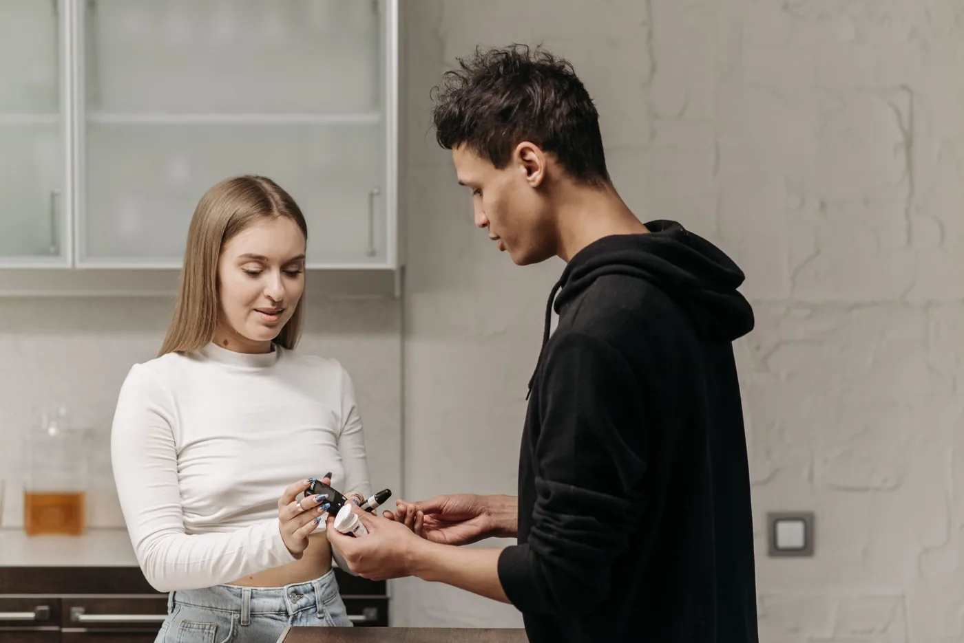 mladý pár měří hladinu cukru v kuchyni