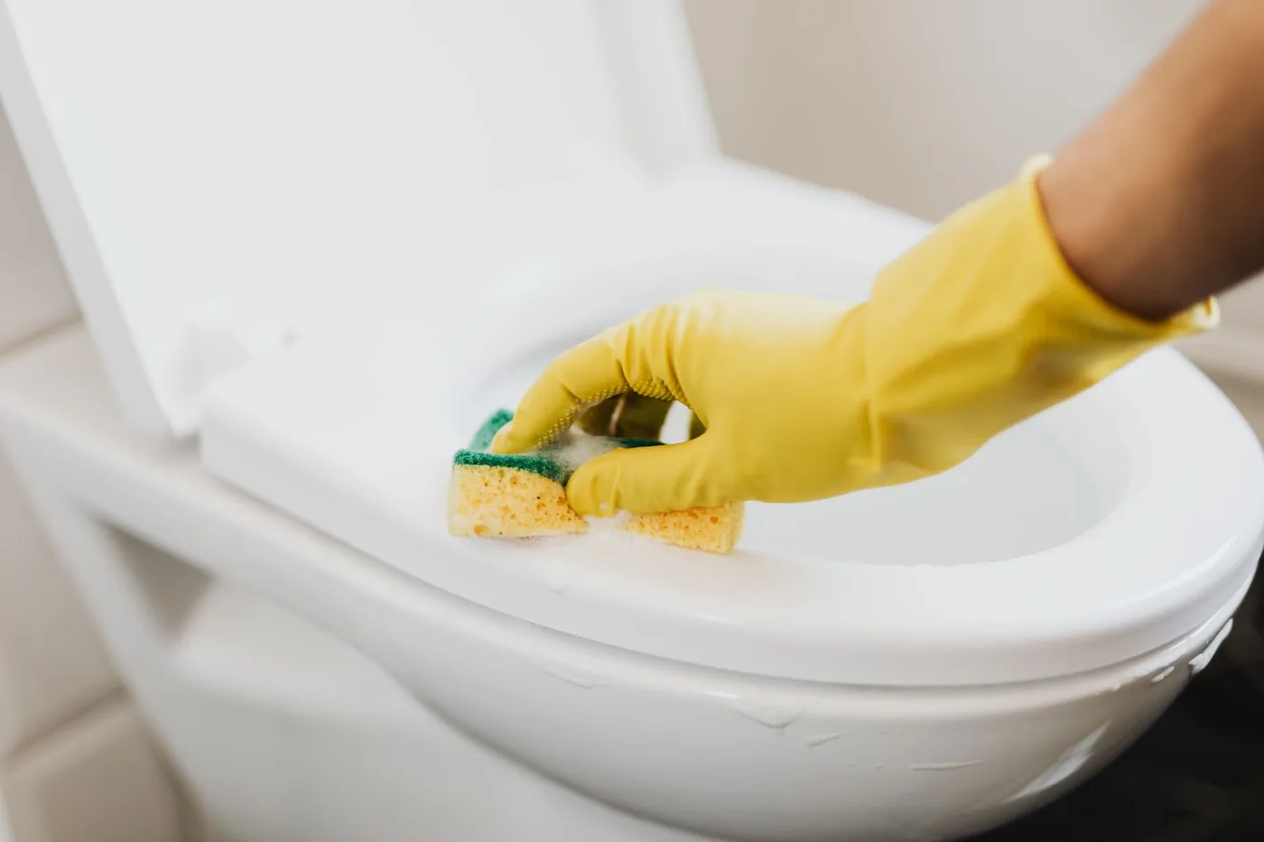 úklid záchodové mísy houbičkou v rukavicích