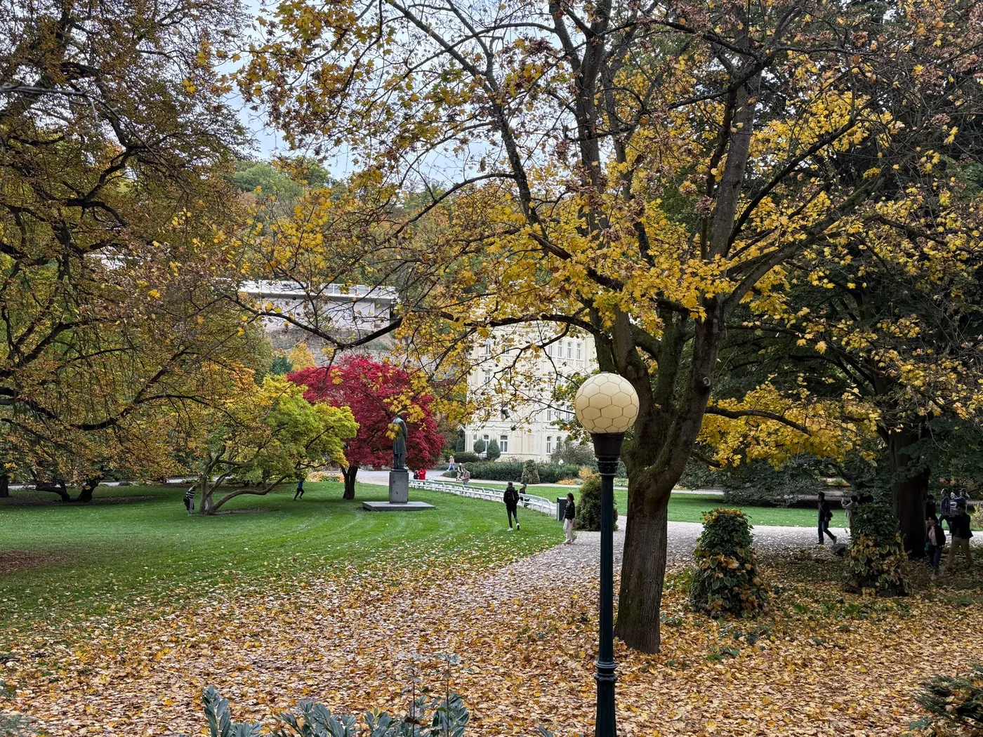 podzimní lázeňský park s barevným listím a sochou