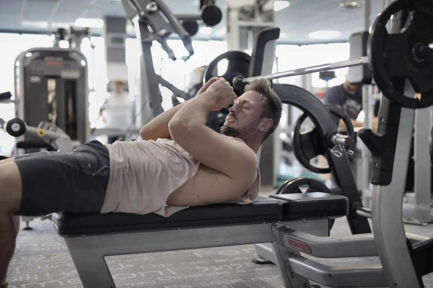 muž cvičí biceps na lavici v posilovně