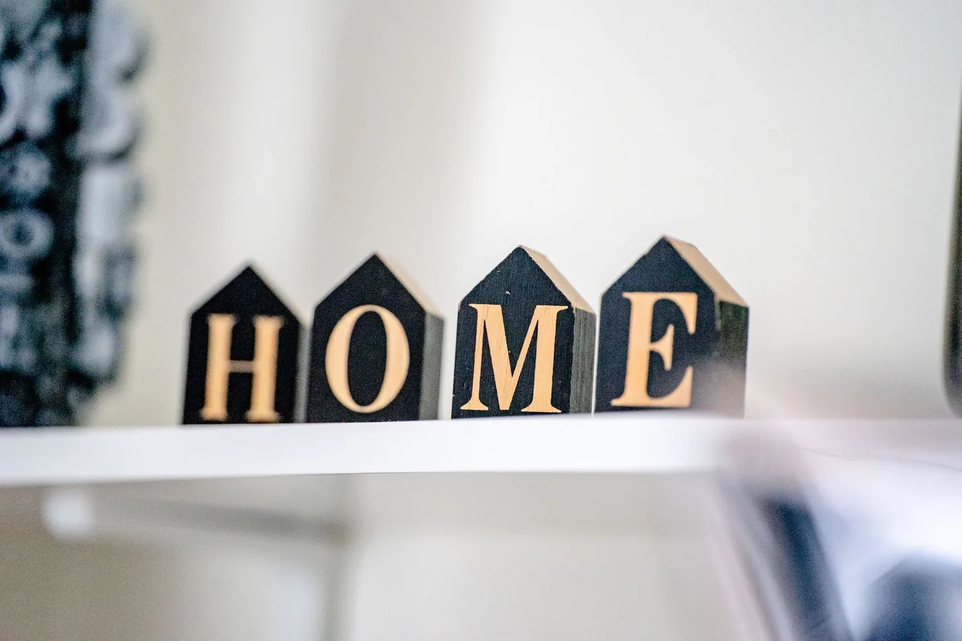 dřevěné kostky s nápisem HOME na poličce